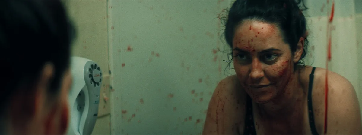 A woman faces a tense moment in a shadowy interior from Do Not Disturb.